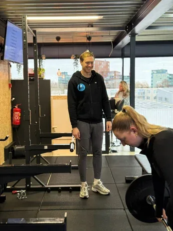 Personal trainer begeleidt een sporter bij een kracht­oefening bij Fit Up Leiderdorp