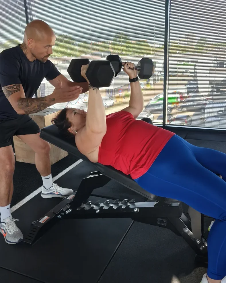 Coach begeleidt klant tijdens krachttraining bij Fit Up Leiderdorp